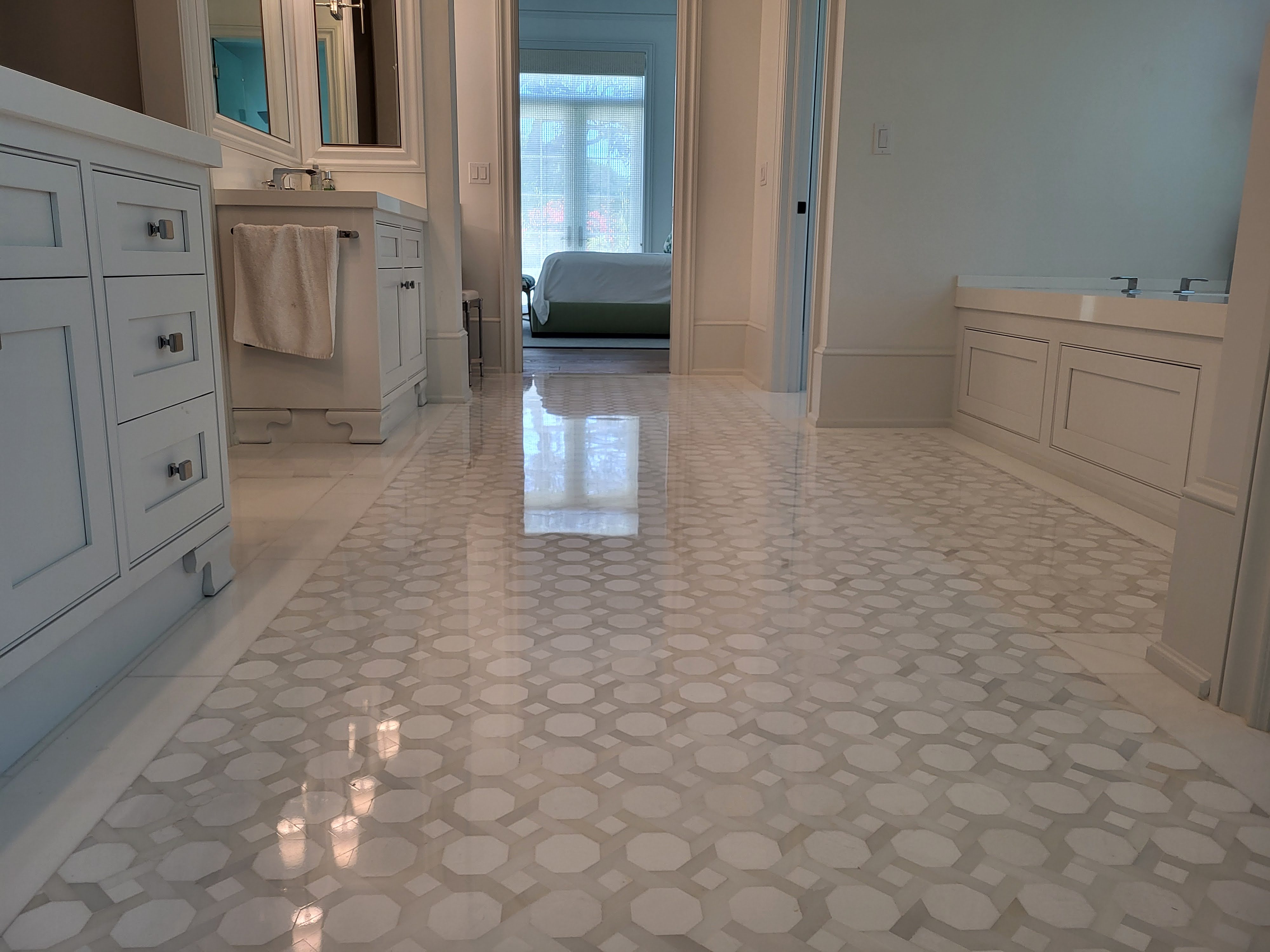 This high-end bathroom features polished mosaic marble with intricate Thassos tiles, creating a luxurious and sophisticated look that elevates the overall design.