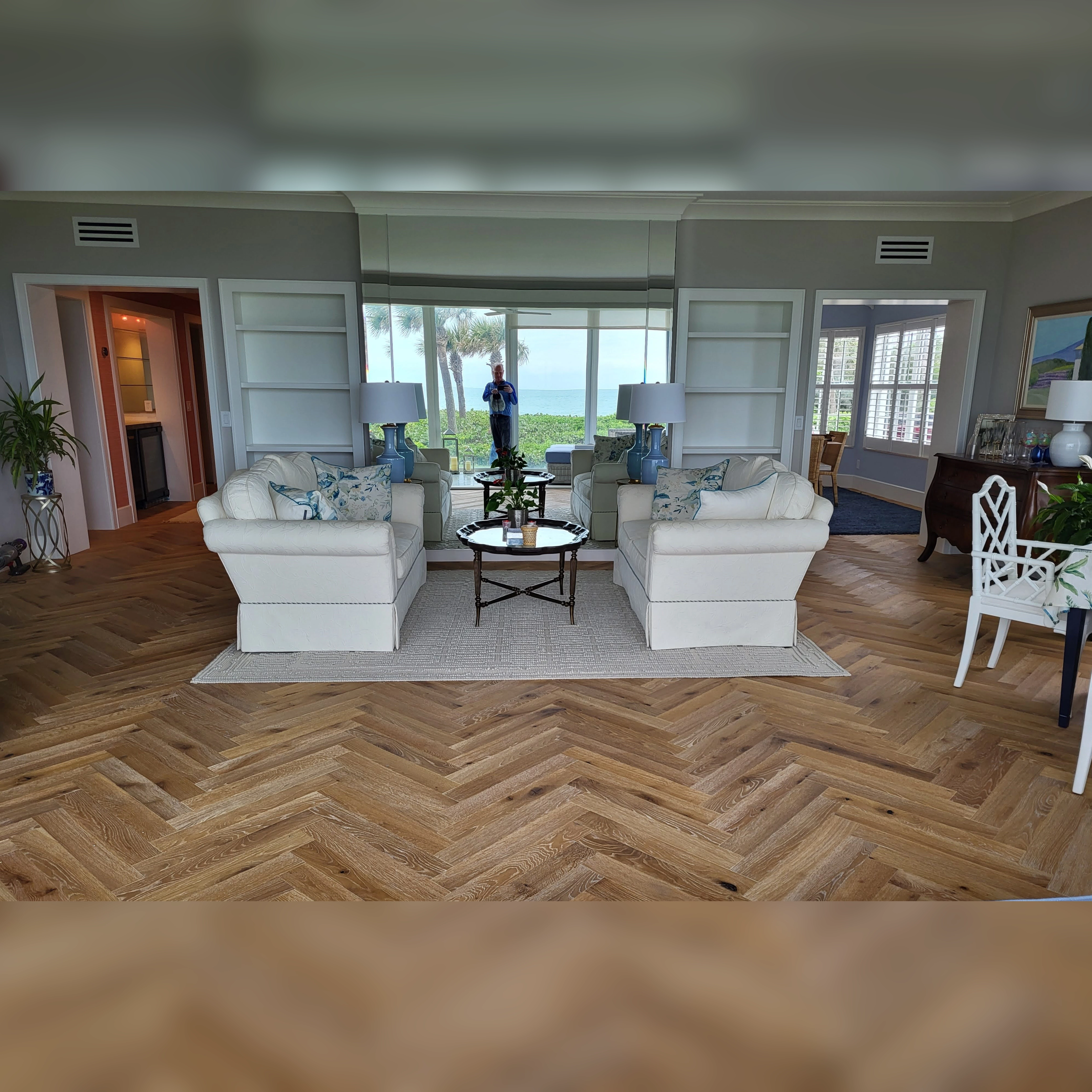 Engineered wood flooring installed in a living room featuring a diagonal herringbone pattern for a stylish and dynamic look.