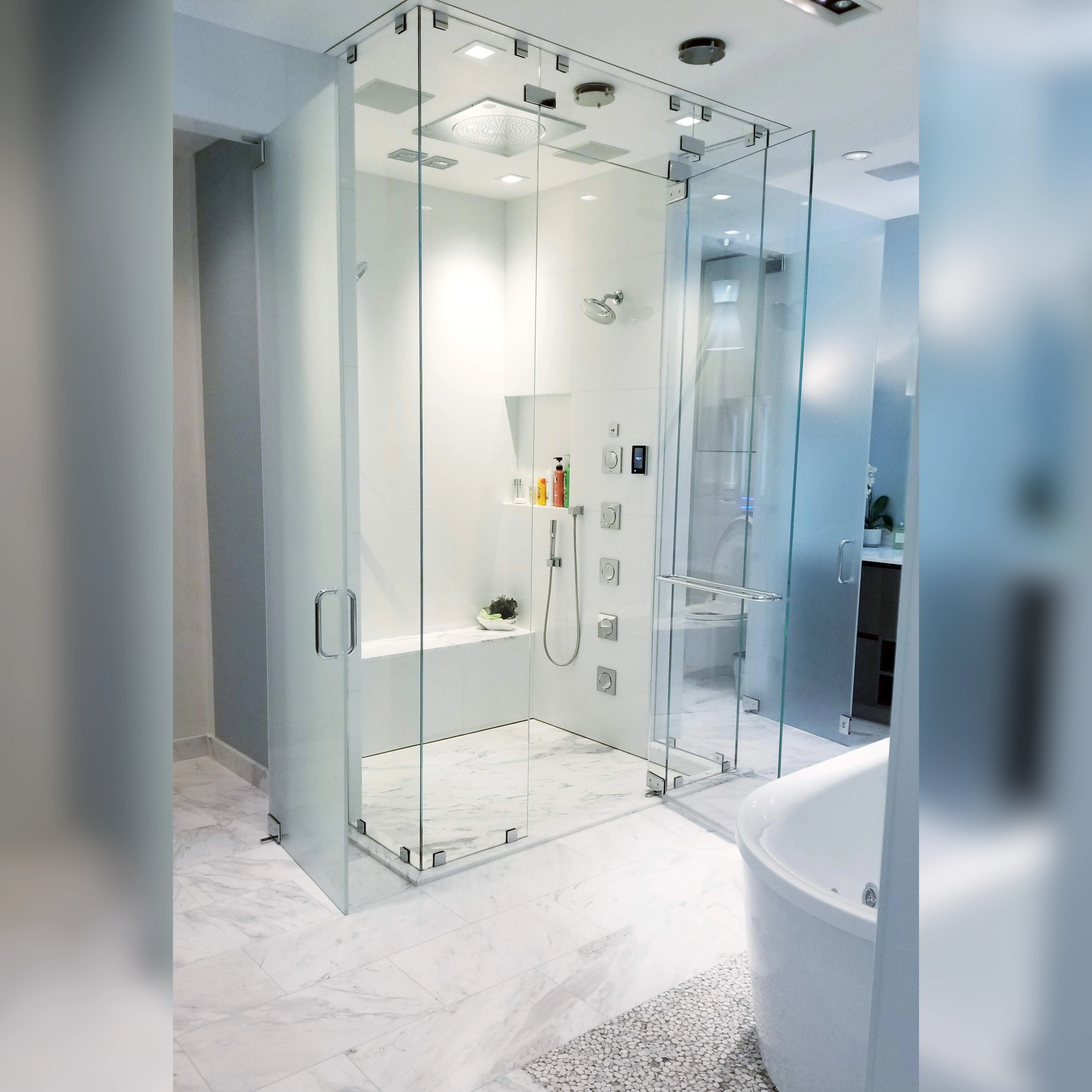 This bathroom showcases a sleek Glassos shower with an infinity drain, complemented by a luxurious marble floor outside the enclosure, seamlessly blending modern design with timeless elegance.