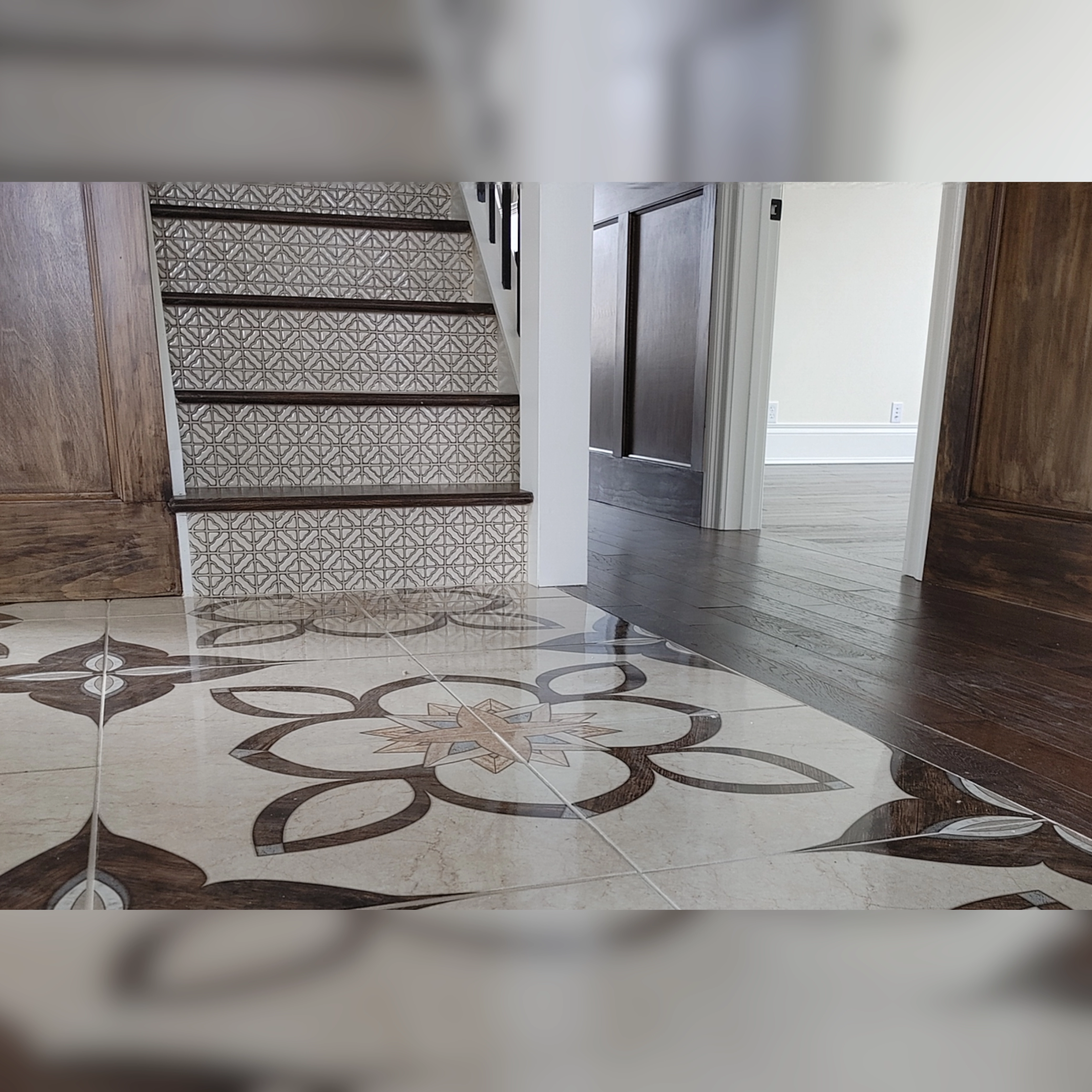 This space features antique-style tiles with intricate patterns, seamlessly integrated into the floor and stair risers, adding a touch of timeless elegance and character to the transitional design.