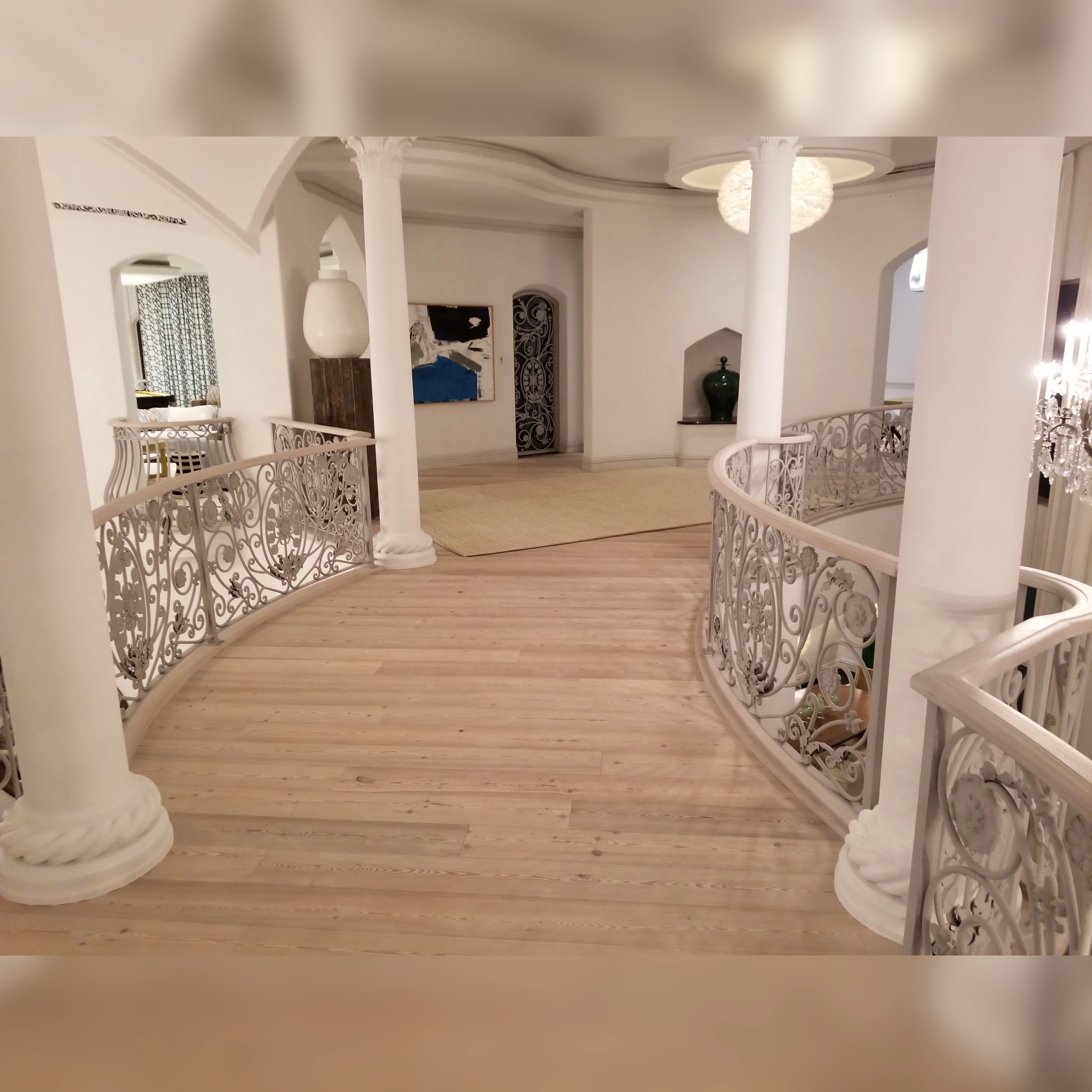 Light-engineered wood flooring installed on a curved bridge, seamlessly integrated with undercut wood railings for a sophisticated and precise design.